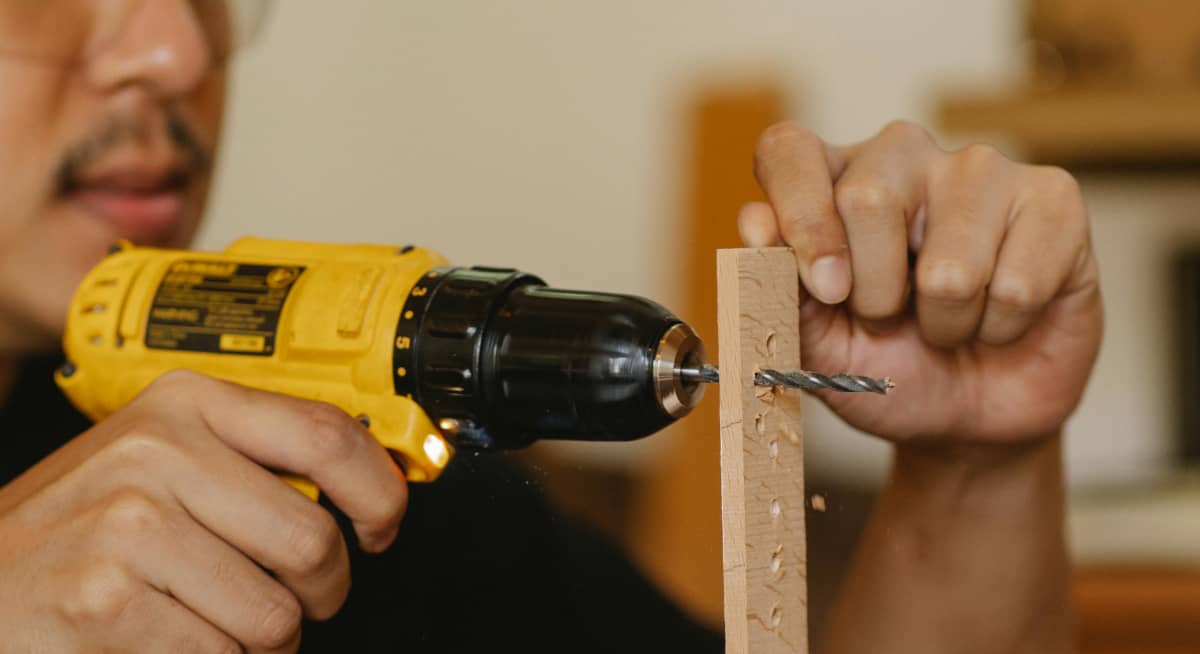 A person using a drill to make a hole
